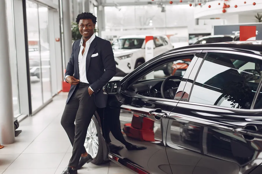 Business traveller beside an executive car, illustrating corporate mobility